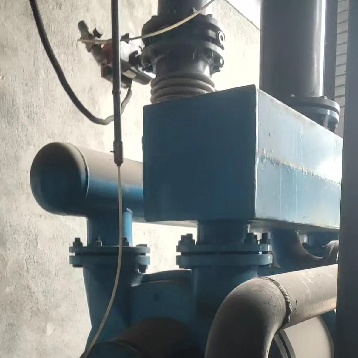 Installed water-ring vacuum pump with flanged piping and a connection enclosure, shown as general context for reviewing site interfaces; not a customer-specific shared-header layout or replacement configuration.